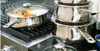 Stainless steel pans with lids on when cooking to suggest how to reduce humidity in the house