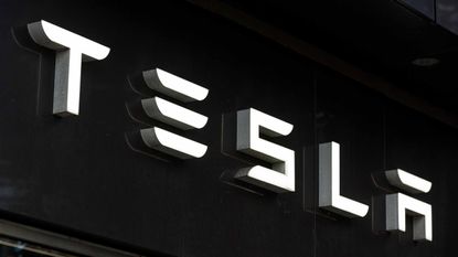 Tesla logo in lights with black backdrop