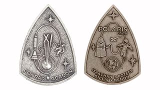 closeup of two triangle-shaped medallions showing astronauts conducting spacewalks