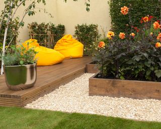 wooden decking with matching raised beds and yellow bean bags