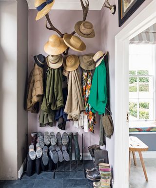 coats and boots in entryway with lots of hats