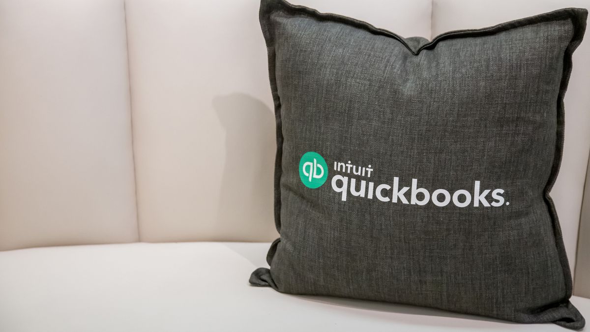 A cushion on a sofa with Intuit&amp;#039;s Quickbooks logo branded onto it 