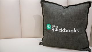 A cushion on a sofa with Intuit's Quickbooks logo branded onto it 