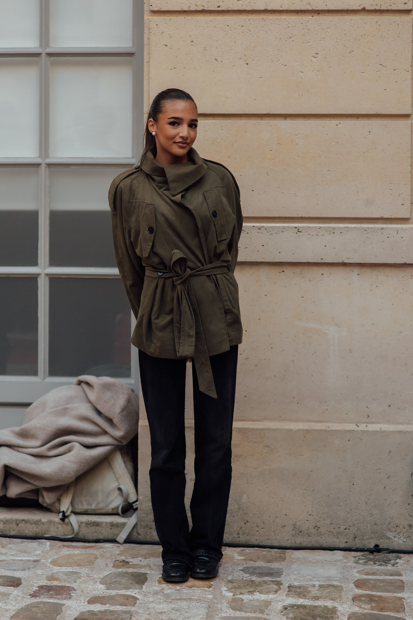 woman wearing stovetop jeans and green jacket