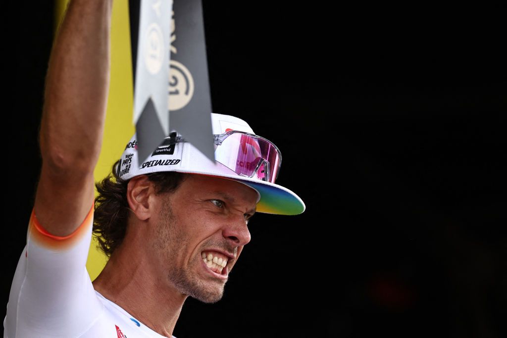 TotalEnergies' Italian rider Daniel Oss celebrates on the podium with the most combative rider award after the 11th stage of the 110th edition of the Tour de France cycling race, 180 km between Clermont-Ferrand and Moulins, in central France, on July 12, 2023. (Photo by Anne-Christine POUJOULAT / AFP)
