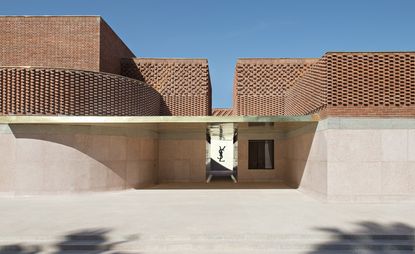 Exterior of the building with intricate brickwork and the Yves Saint Laurent logo