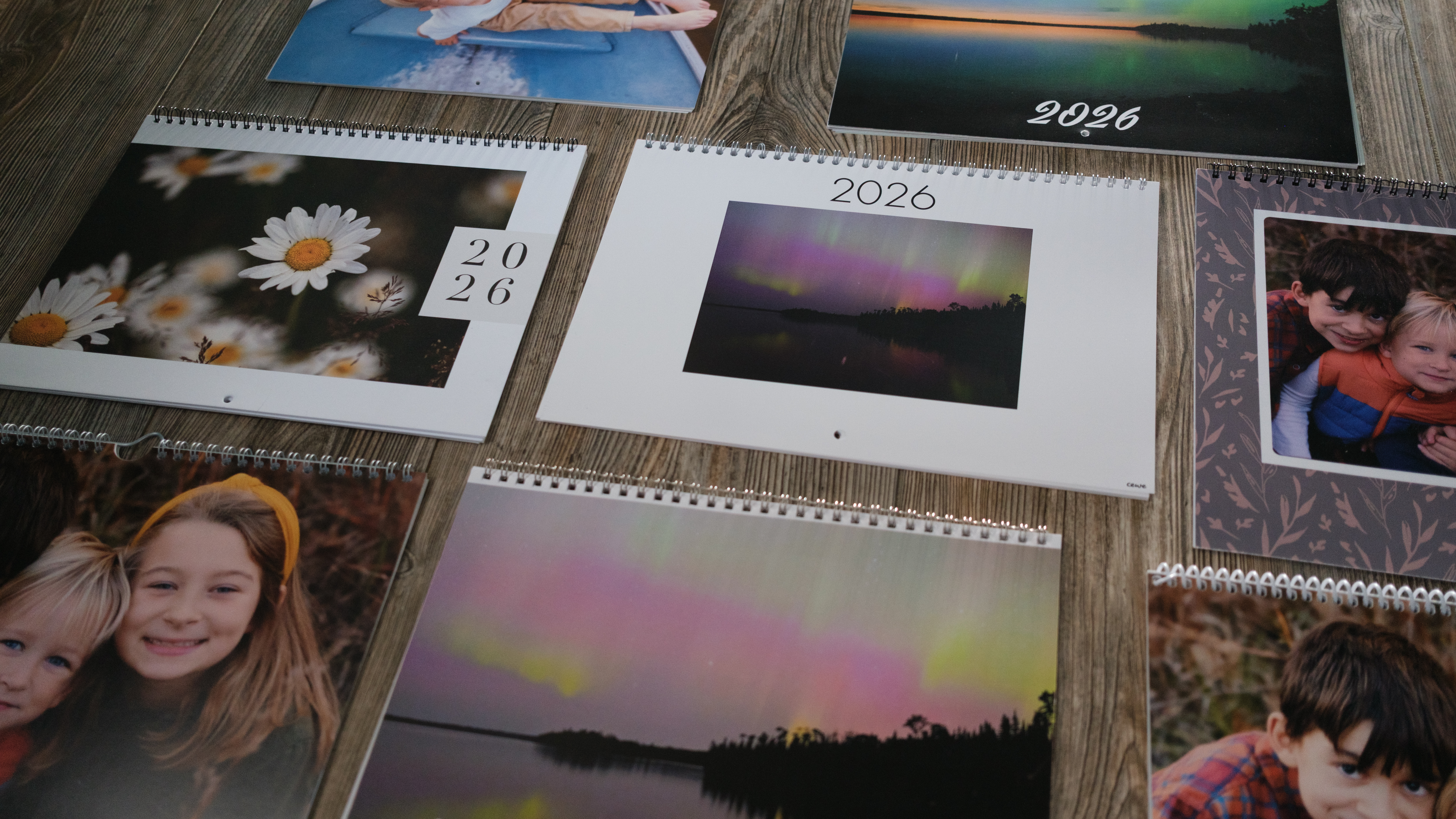 A collection of several custom photo calendars on a wood background