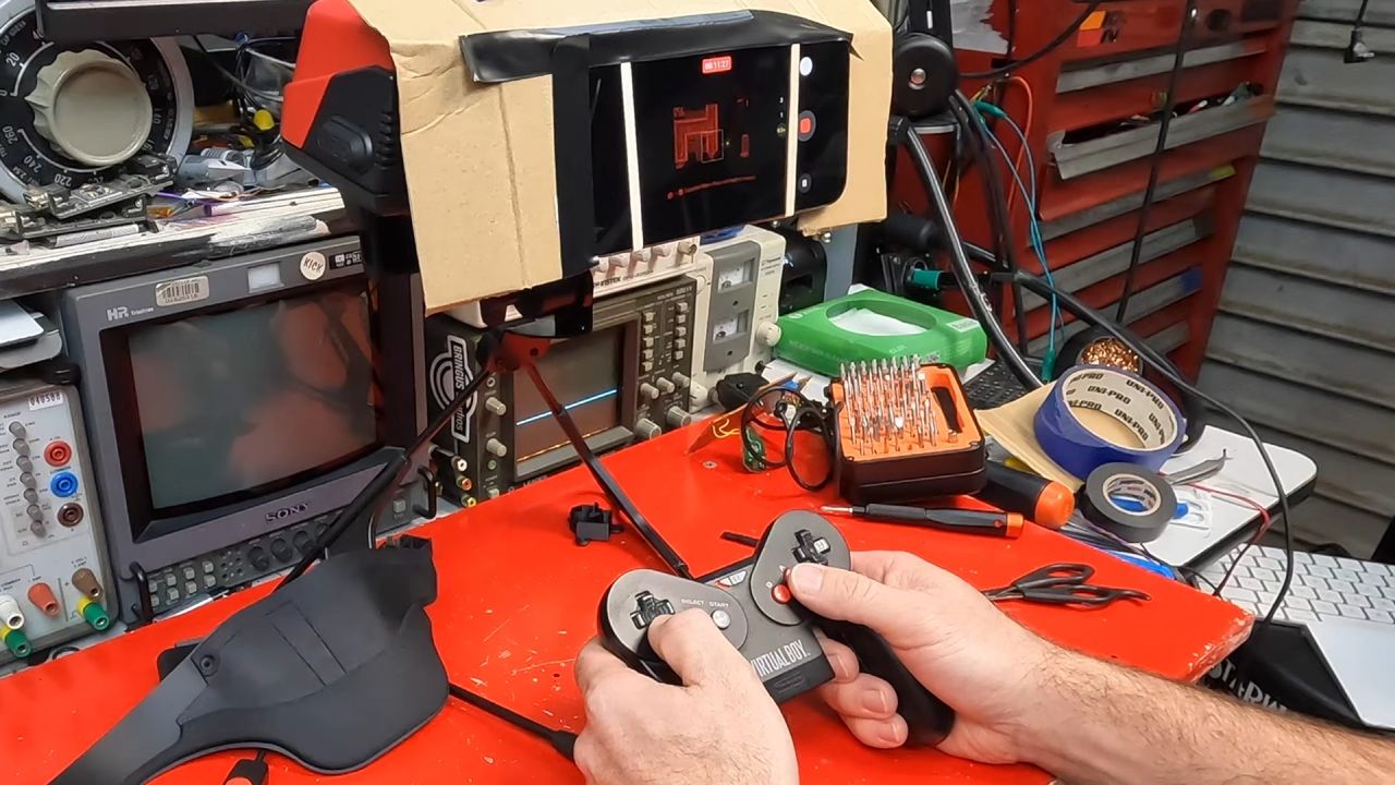 James Channel using modded Virtual Boy controller to play games through phone strapped to headset for recording.