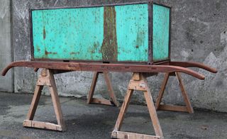 Concrete wall and floor rustic wooden frame, rusty green metal box on top