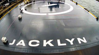 closeup of a ship's deck, which has a large white painting of a feather and the name "jacklyn" in white block letters