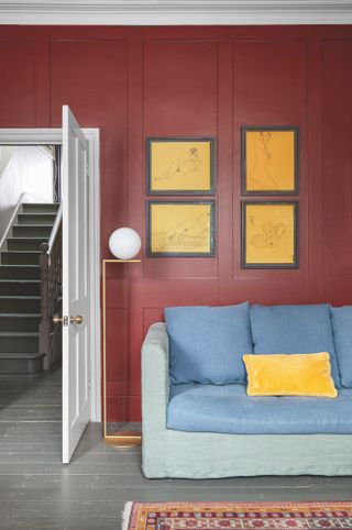 Colour block blue and green sofa against deep red wall