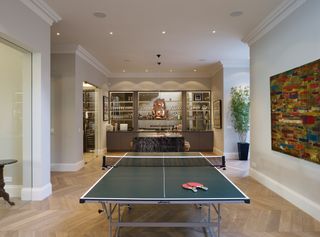 room with table tennis and bar, herringbone flooring, marble island, brass pendant lights