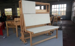 A wooden sitting arrangement, that looks like a paper-making machine, making the sitting area white.