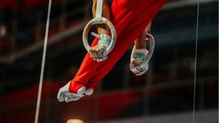 Man competing in gymnastics rings event