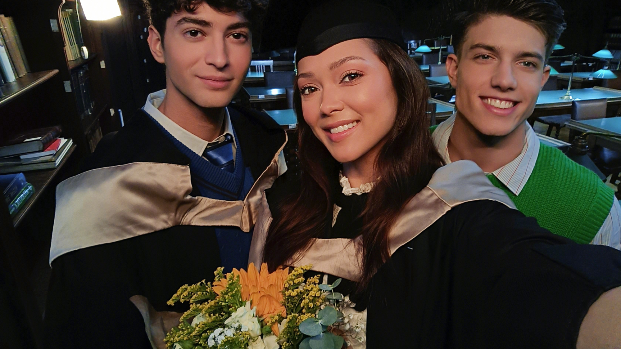 The Oppo Reno 11 5G being used to take a portrait photo of three graduates