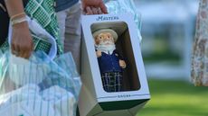 A Masters gnome in a box being carried by a patron at the 2024 Masters