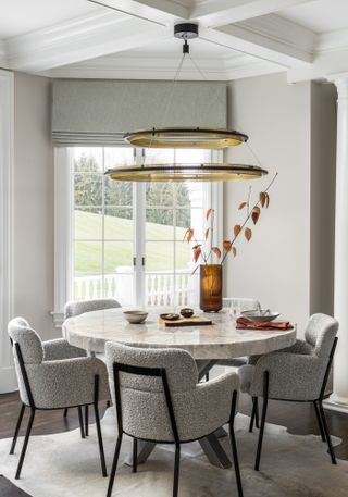 Dining room with round marble table and boucle chairs