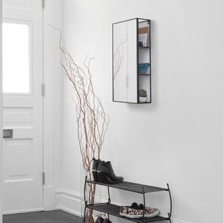 A white hallway with mirror wall cabinet