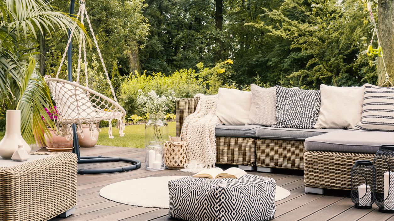 outdoor living scene with hanging chair and corner sofa