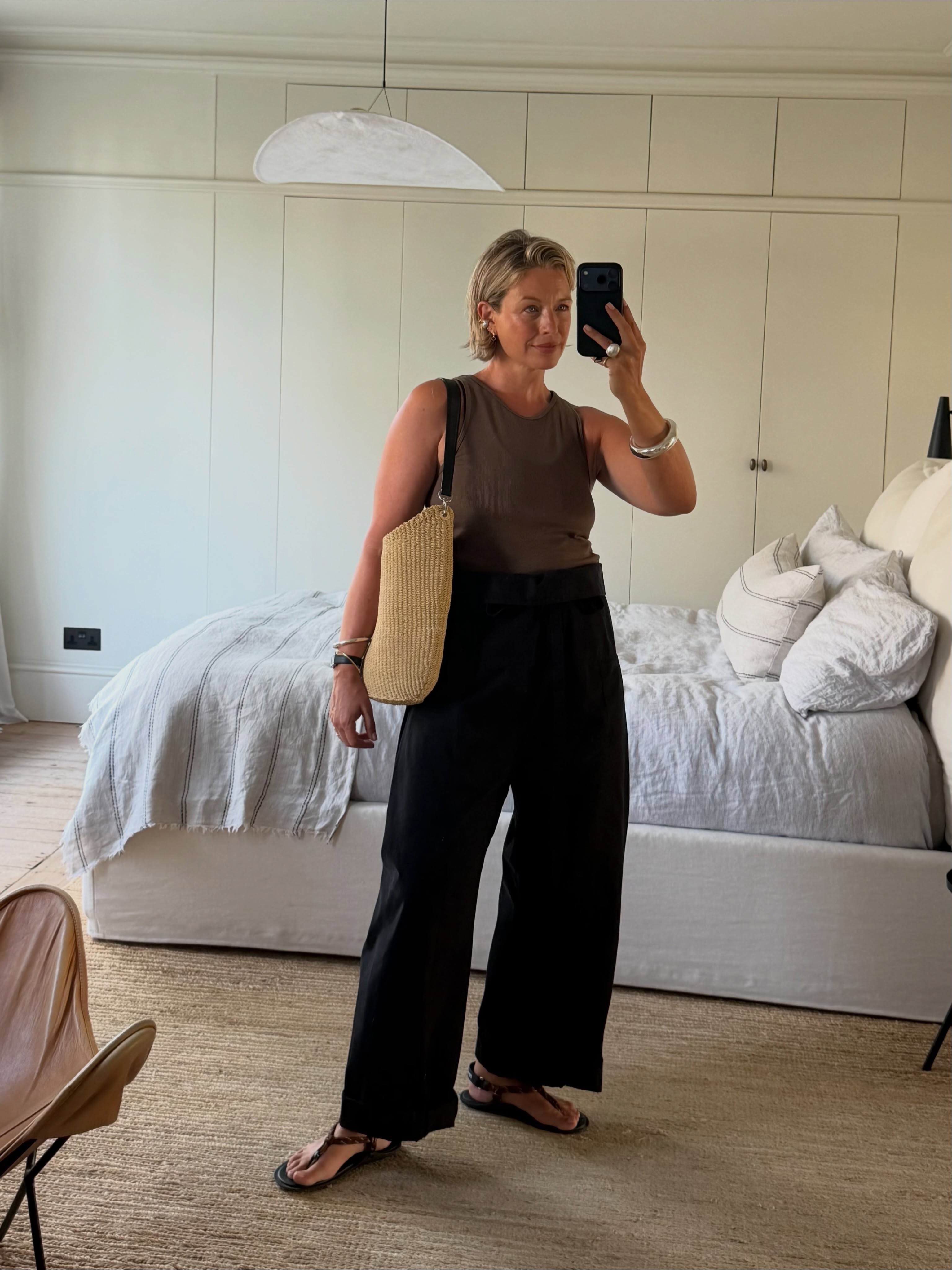 alexis foreman wears a khaki top, black trousers and rope sandals