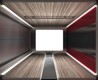 Interior view from below of an Otis lift featuring metal doors, buttons, lighting, a handrail and wood, metal and red coloured panels