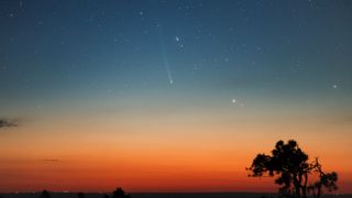 A sunset with a faint comet flying through the sky