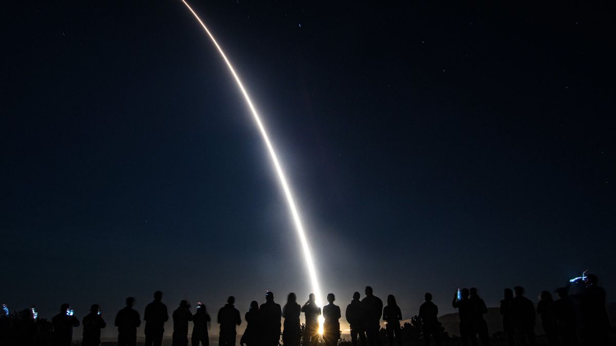 silhouette people watching bright arc into sky