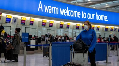A passenger pushes her bags through Heathrow Airport