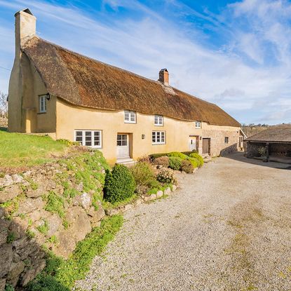 venton farm exterior with thatched roof and white windows