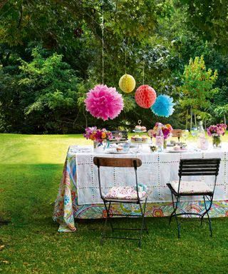 A table set up on a lawn with colorful paper decorations