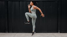 Woman runner skipping, with one knee raised to hip height