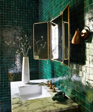 green tiled bathroom with mirrors and sink