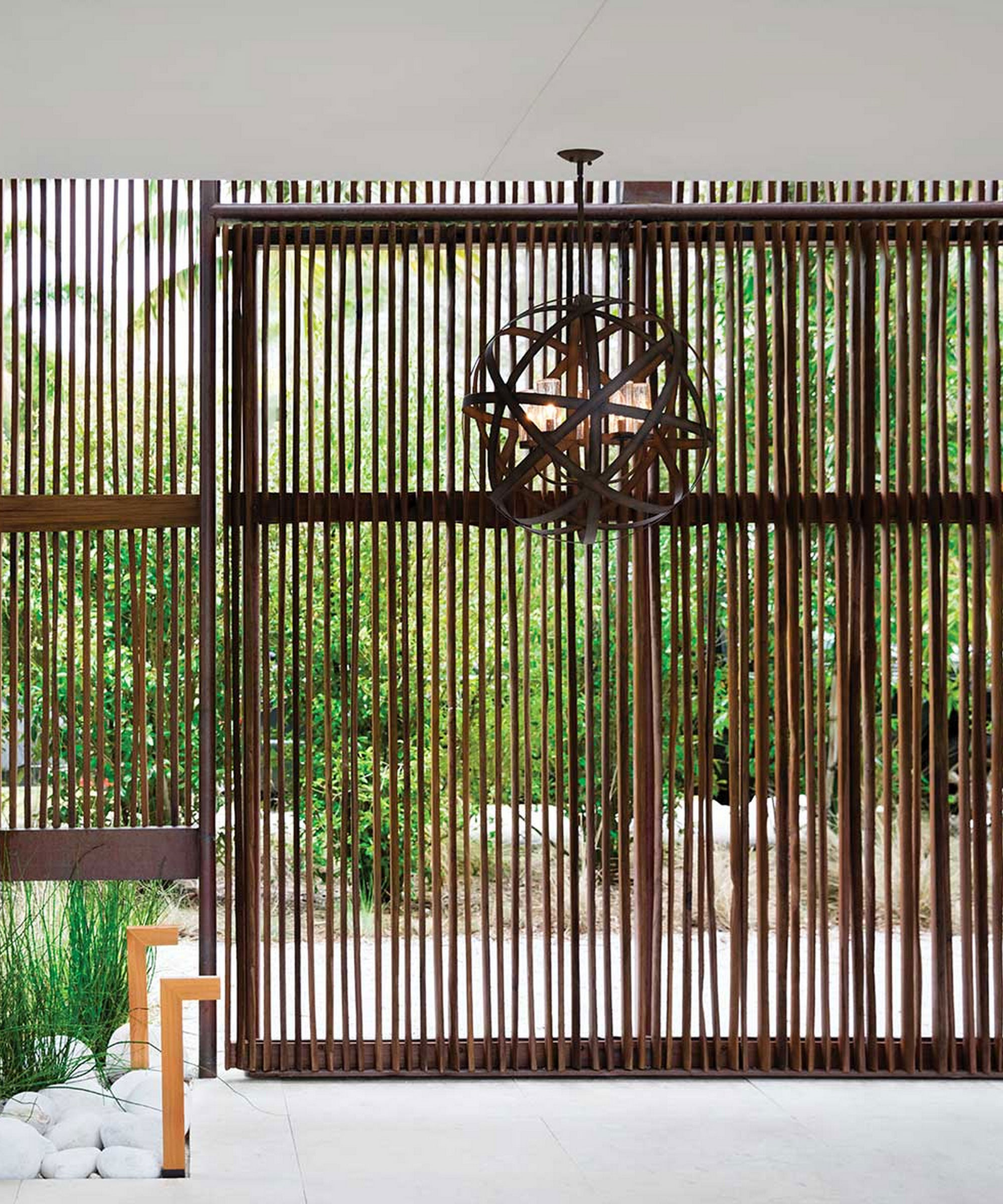 paved garden area with decorative screen and pendant lighting