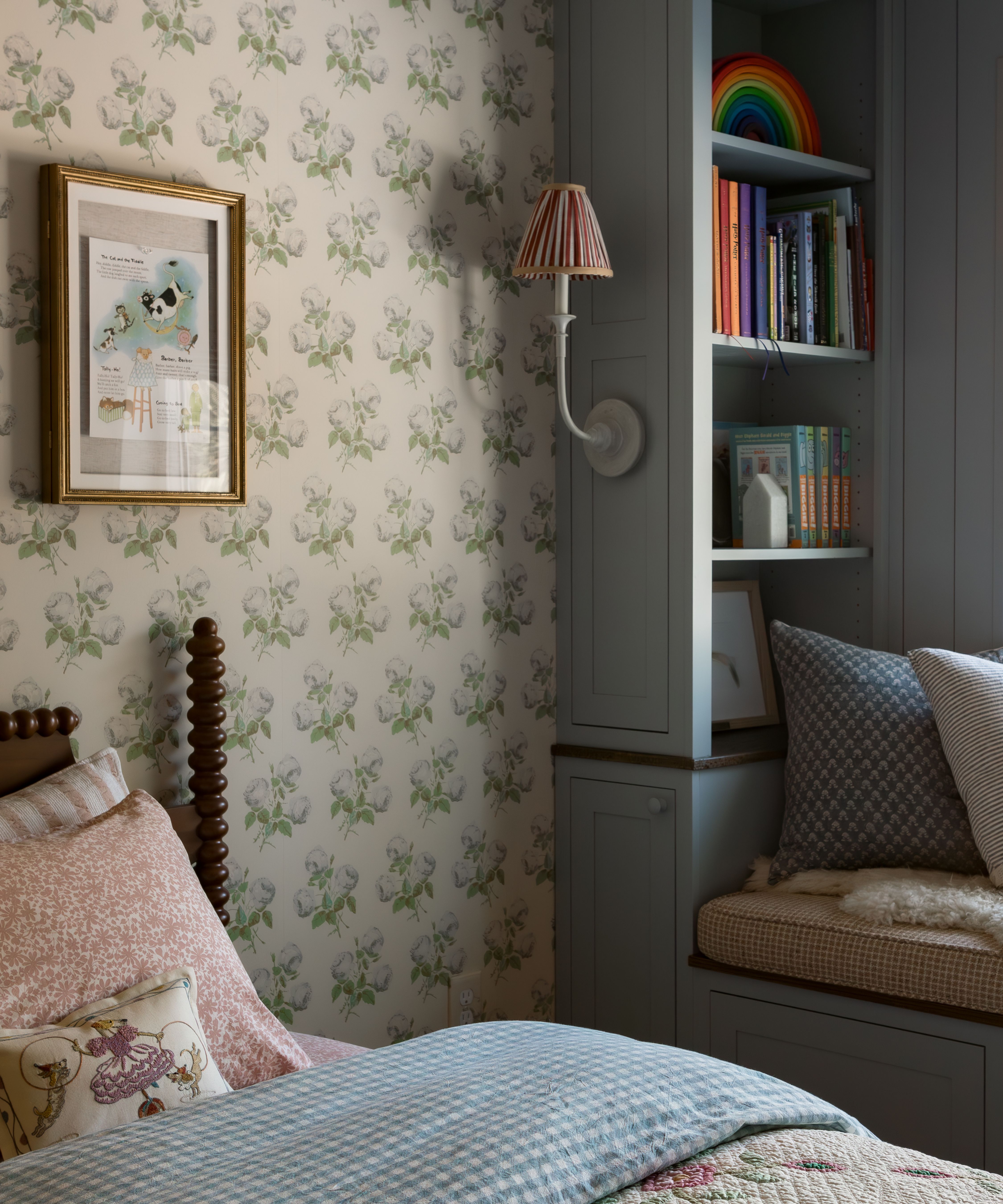 a classic foral wallpapered bedroom with french blue painted window seat and joinery