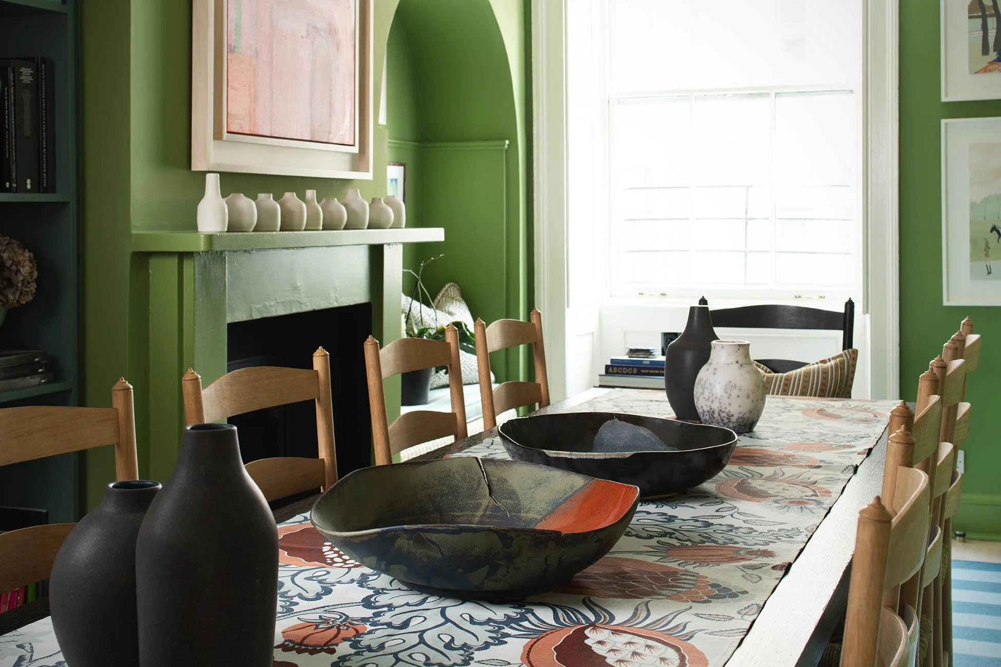 objects arranged along a dining table in a green room