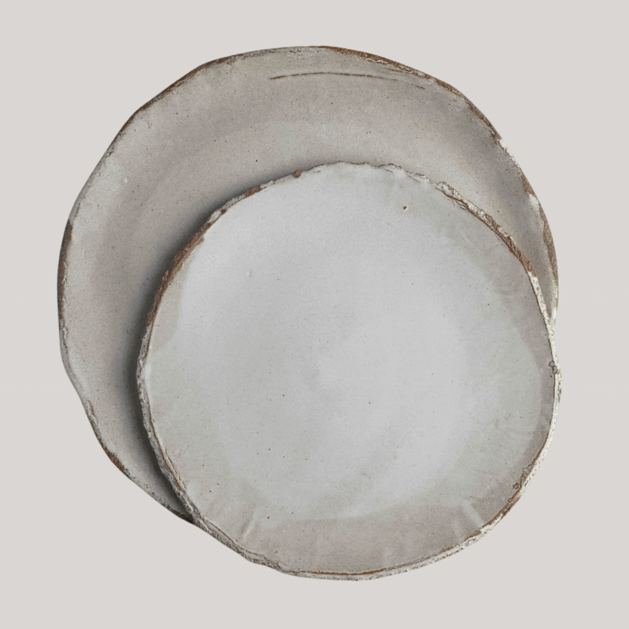 A rotating gif showcasing a series of white ceramic plates with organic silhouettes.