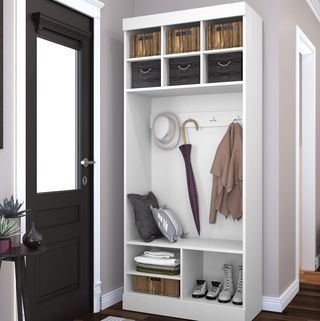 A mudroom idea bookshelf with compartments for storage, wall hooks and baskets