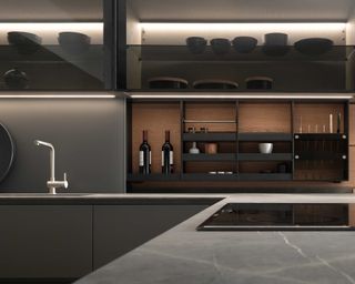 A modern, dark gray kitchen with mood lighting and a shallow storage cupboard concealed behind a sliding backsplash