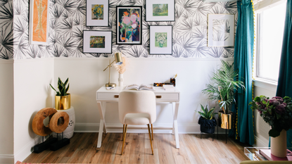 Desk area in bright apartment bedroom. space styled with houseplants, gold accents, and a gallery wall