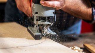 Close up of person cutting wood with a jigsaw