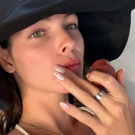 Selfie of Vittoria Ceretti wearing a hat and holding blush