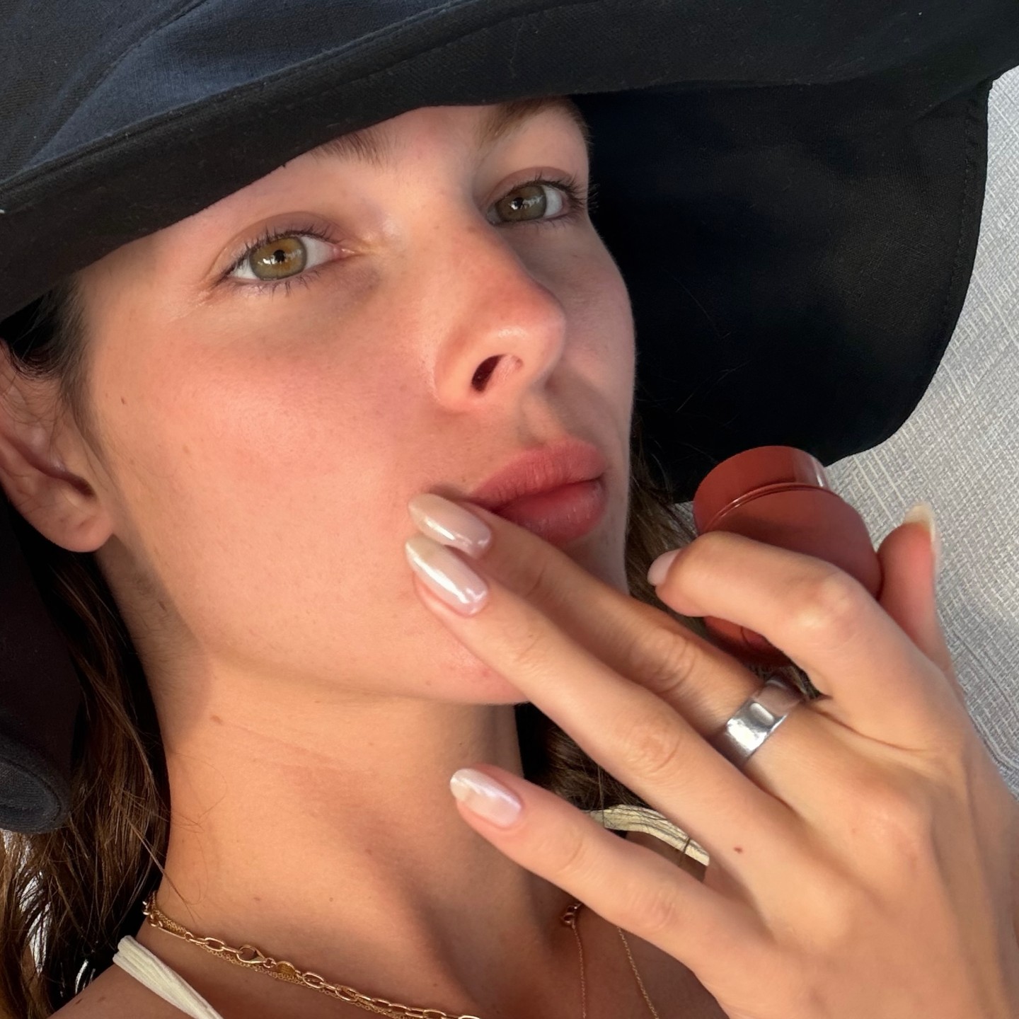 Selfie of Vittoria Ceretti wearing a hat and holding blush