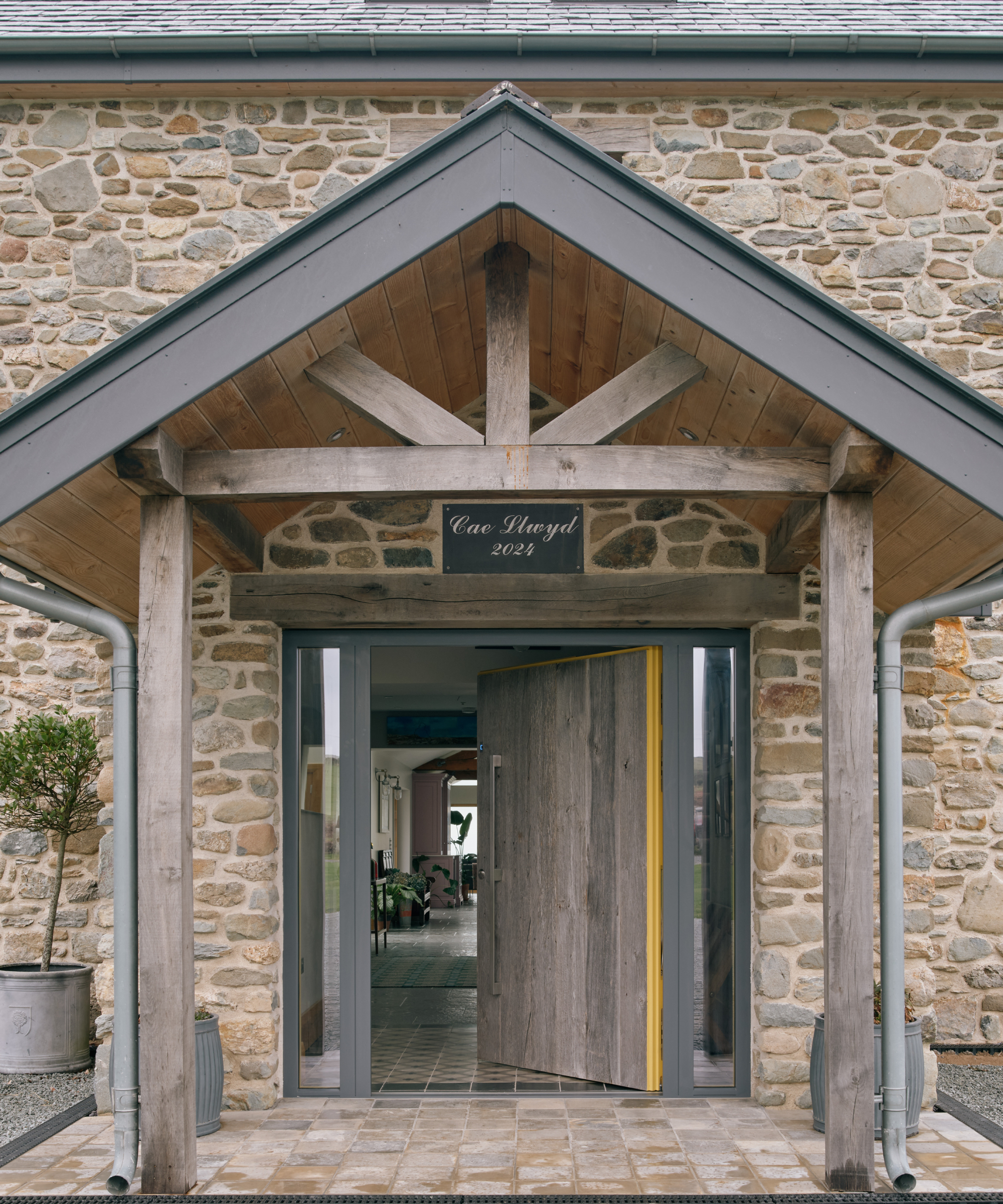 large porch with timber beams and struts and large matching wood front door