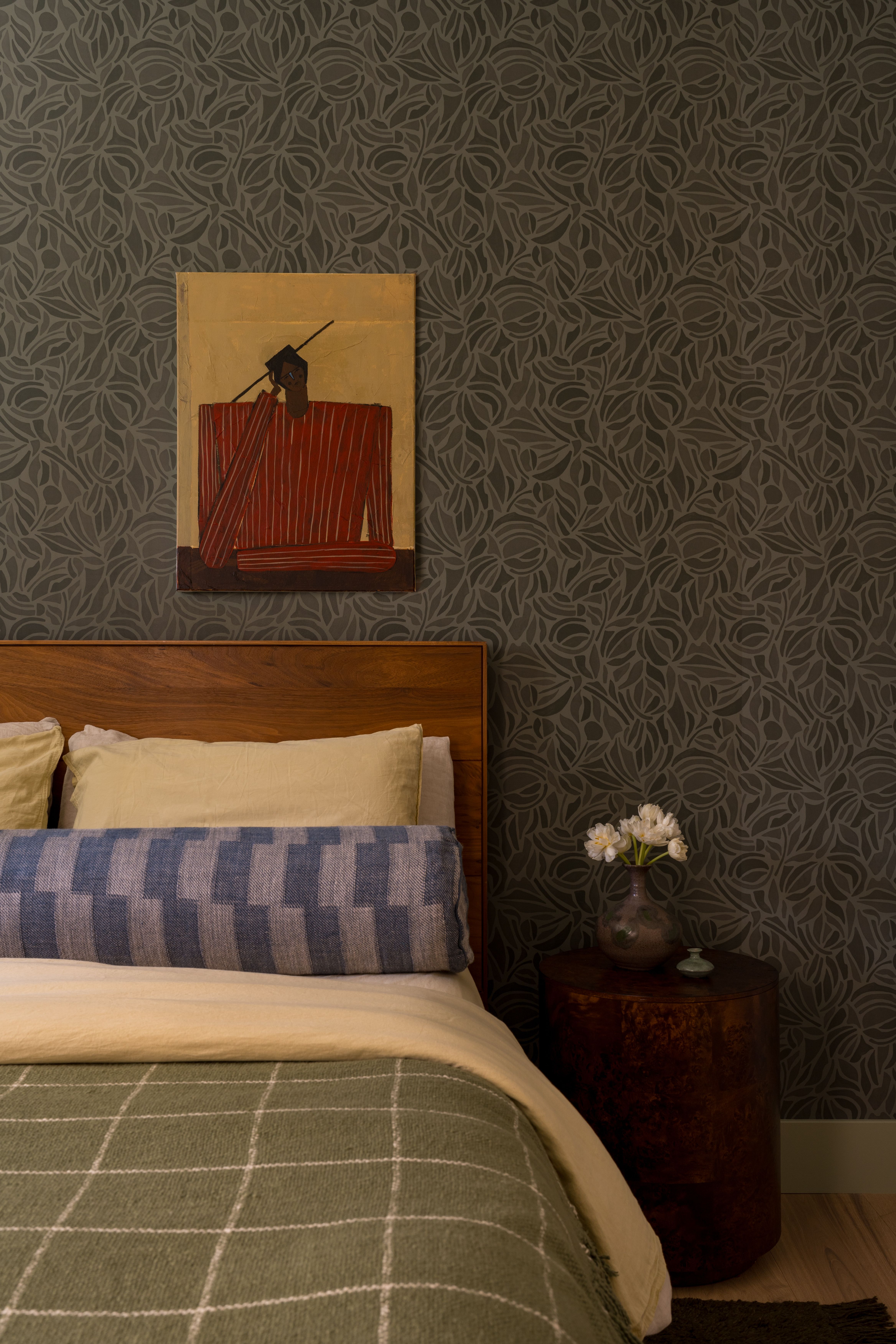 Bedroom with bed, artwork, side table and wallpaper
