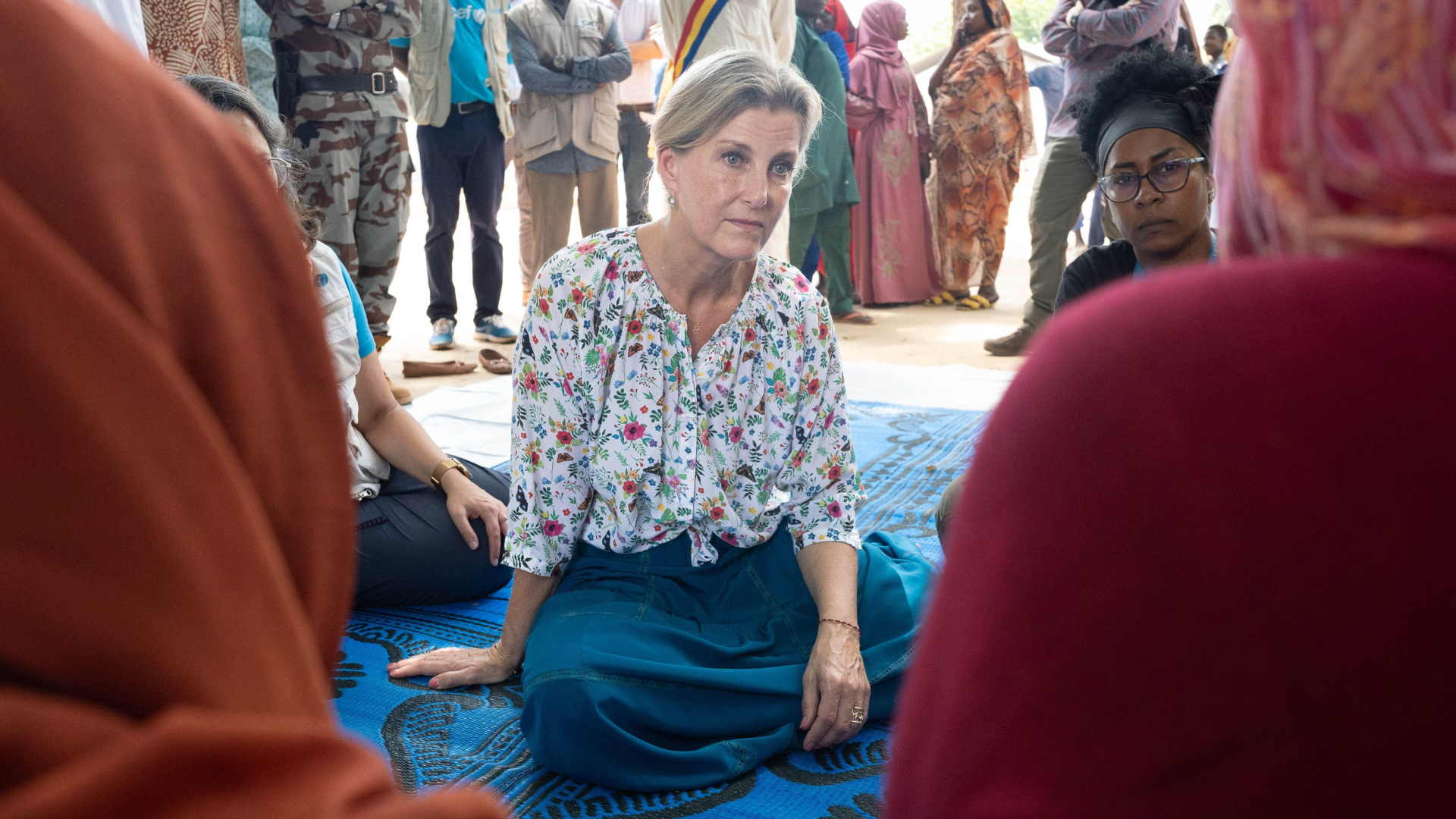 Duchess Sophie sitting on a blue blanket talking to women