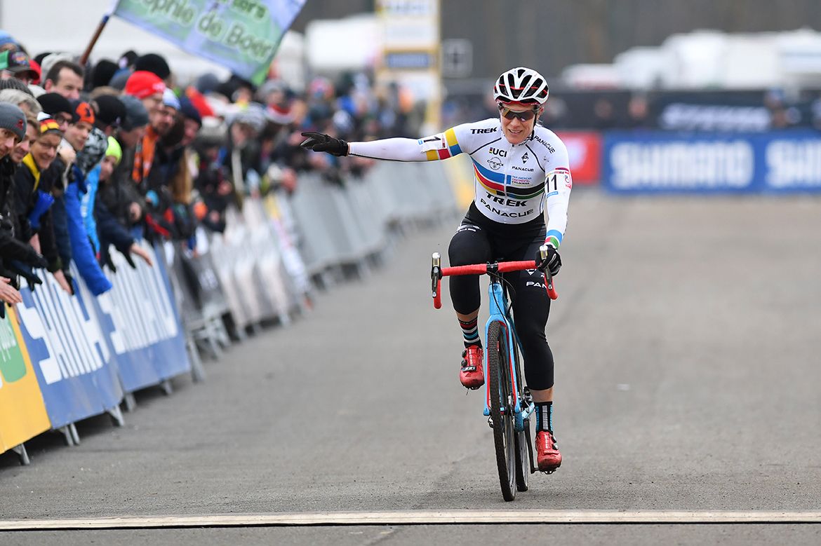 Katie Compton waves as she crosses the line
