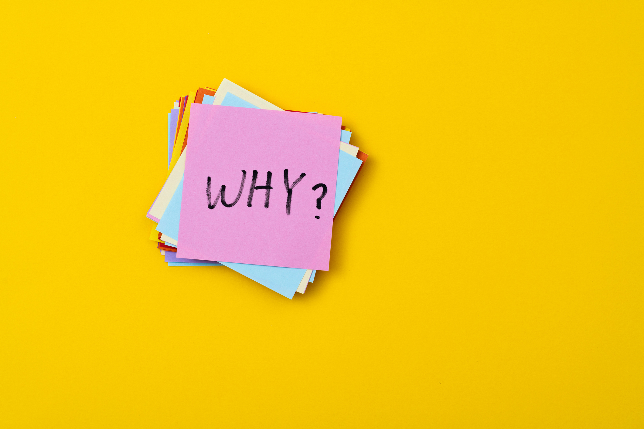bright yellow background with a stack of multi-colored Post-it notes and the pink one on top reads "Why?"