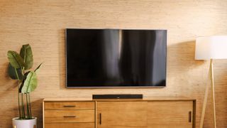 Bose Smart Soundbar 600 on wooden credenza with TV above it