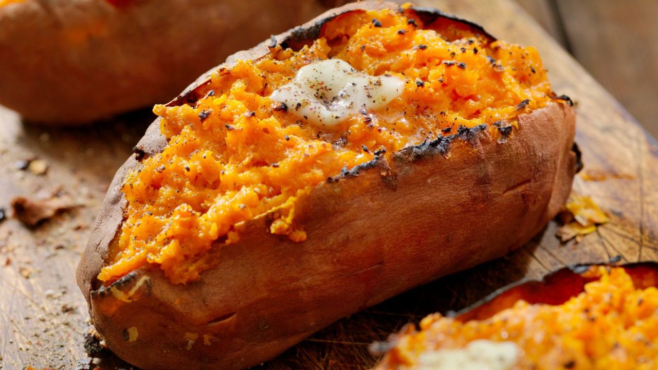 A close up of a cooked sweet potato with melting butter