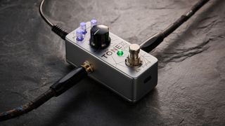 IK Multimedia Tonex One Bass: the mini-pedal offers amp modelling and heaps of tone options and is here photographed against a slate floor.